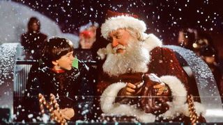Bästa julfilmer: Charlie och jultumten sitter bredvid varandra på en bänk utomhus i julfilmen Nu är det jul igen.