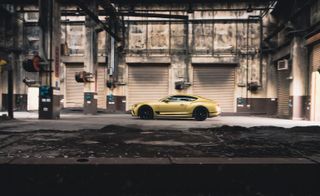 Bentley Continental GT Speed in gold side view in a warehouse