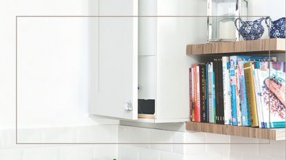Close up of a white cabinet concealing a boiler next to open wooden shelves filled with books