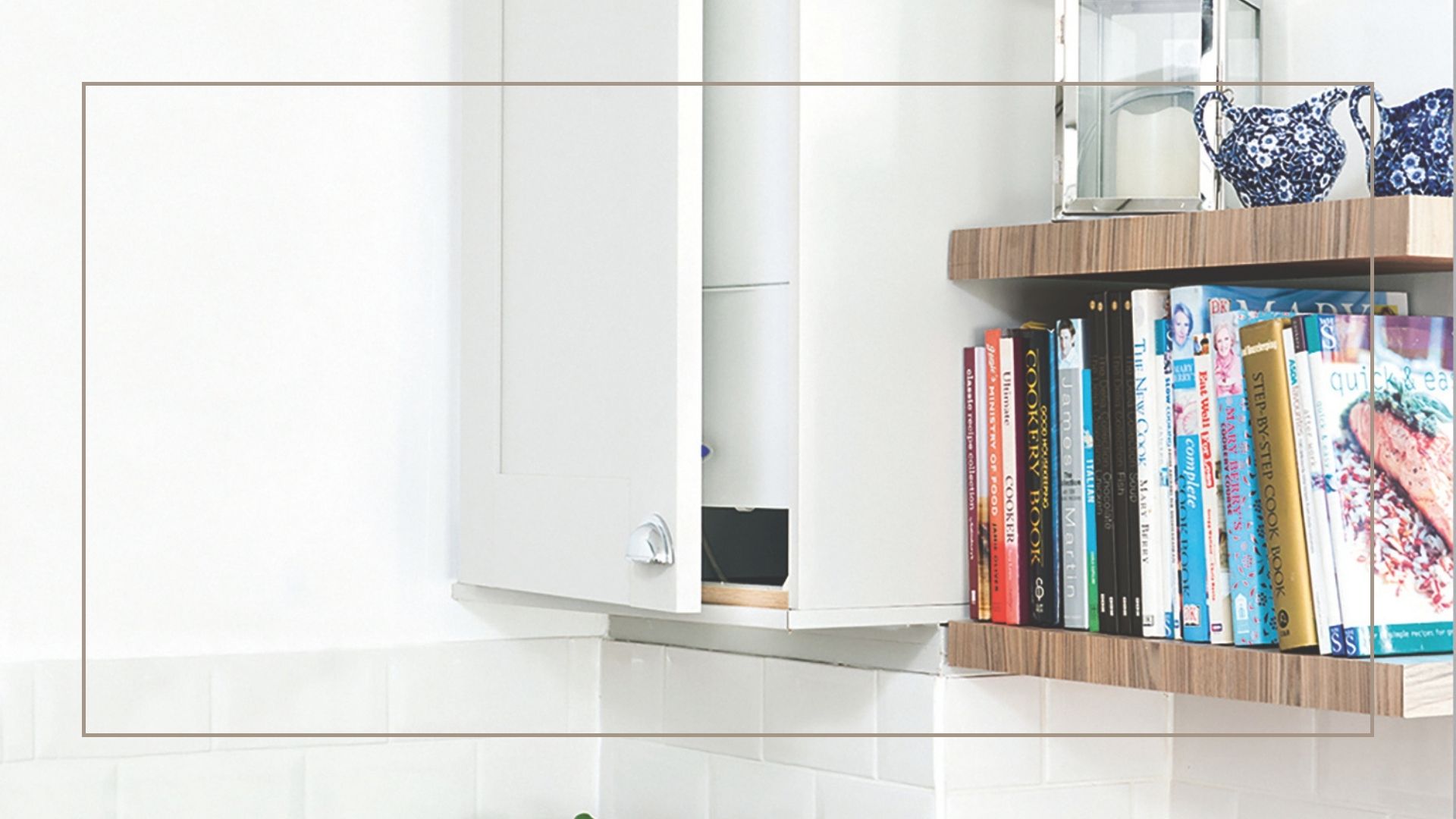 Close up of a white cabinet concealing a boiler next to open wooden shelves filled with books