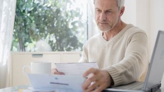 Should you file for bankruptcy? image shows man looking at bills