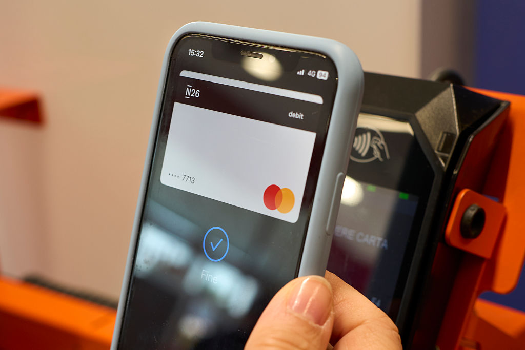 Customer holds a smartphone displaying an N26 debit Mastercard