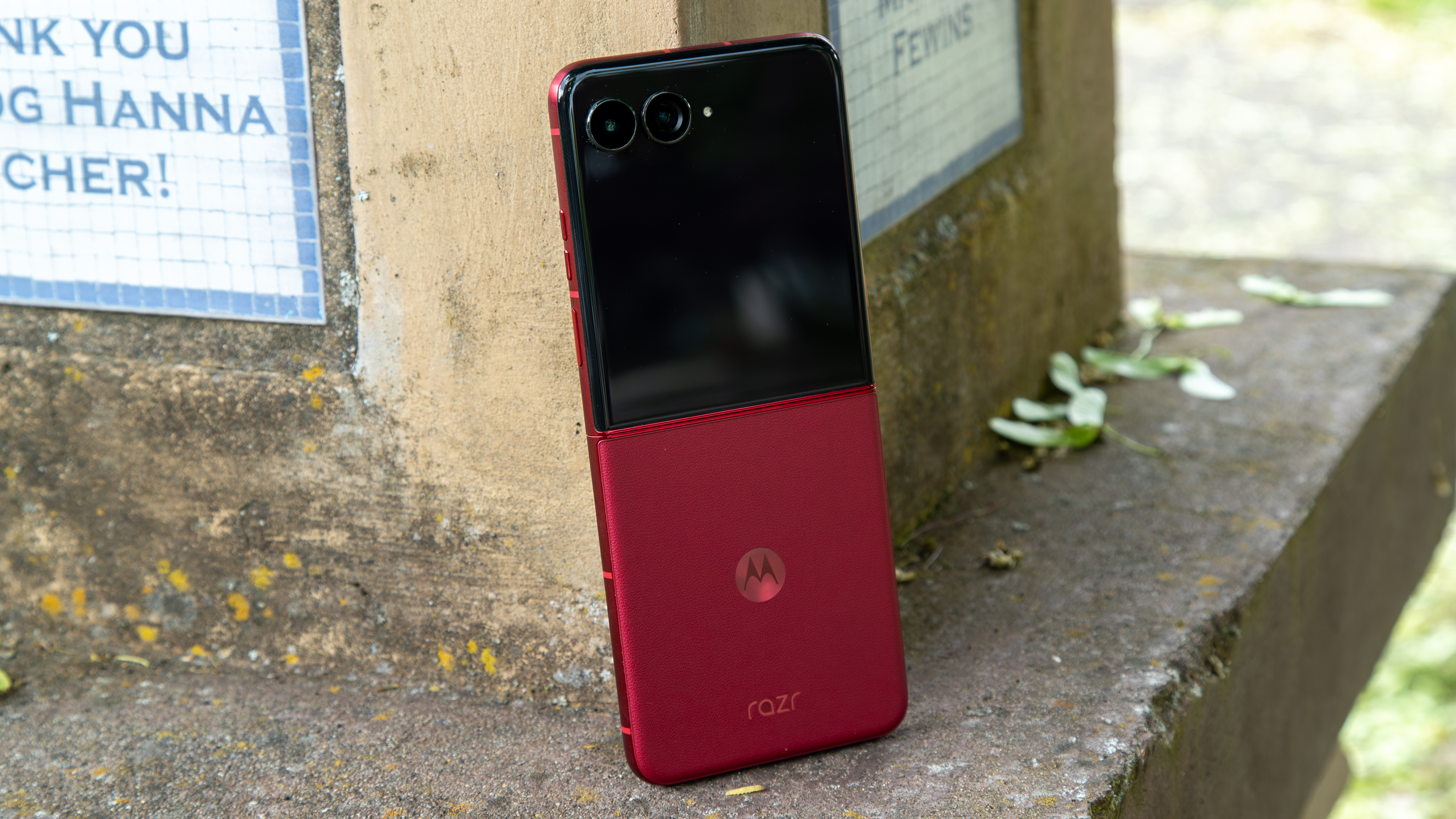 The Razr Ultra 2025 open and leaning against a pillar