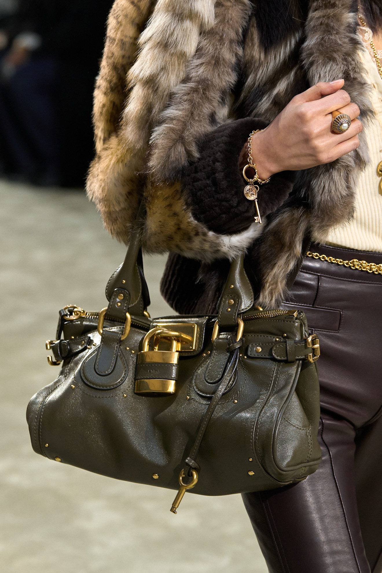 a model at Chloé Fall 2025 carrying a green Paddington purse with a gold padlock