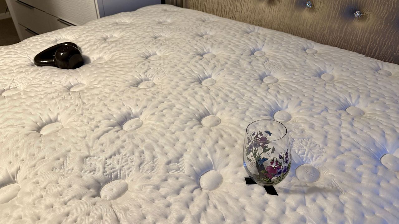 Testing the Winkbed mattress's motion isolation qualities with a weight and a wine glass