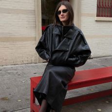 @cocoschiffer wears a pair of Dolce Vita cow-print calf-hair heels, with sheer tights, a slip skirt, and oversized funnel-neck leather jacket. 