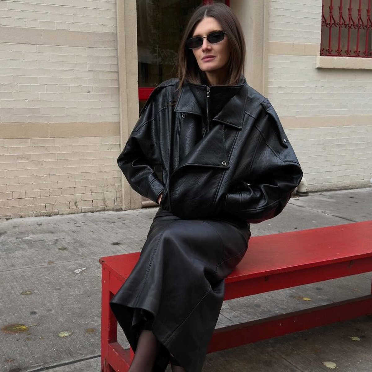 @cocoschiffer wears a pair of Dolce Vita cow-print calf-hair heels, with sheer tights, a slip skirt, and oversized funnel-neck leather jacket. 