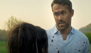 Ryan Reynolds looks horrified in a bloody shirt in The Hitman's Wife's Bodyguard.