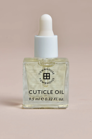 A bottle of Townhouse cuticle oil set against a pale background.