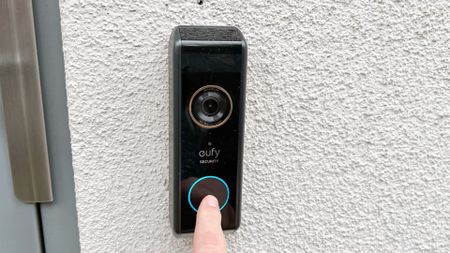 Person pressing button on Eufy Video Doorbell Dual