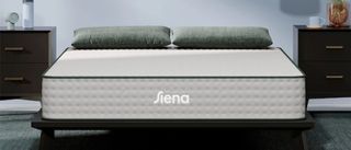 The Siena Premier Hybrid Mattress shown here on a black wooden bedframe in a bedroom painted with light blue walls performed well in all of our mattress tests and proved itself good value for money