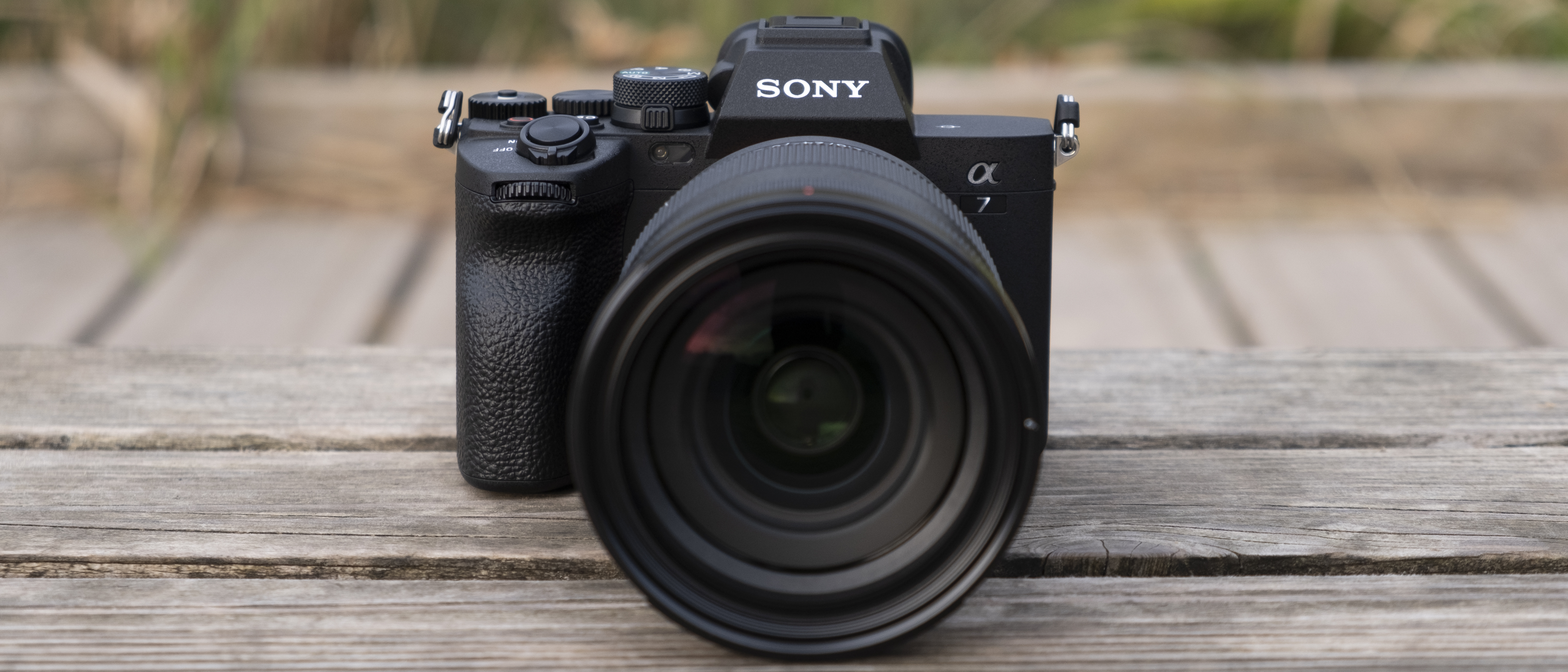 The Sony A7 IV camera sitting on a wooden bench