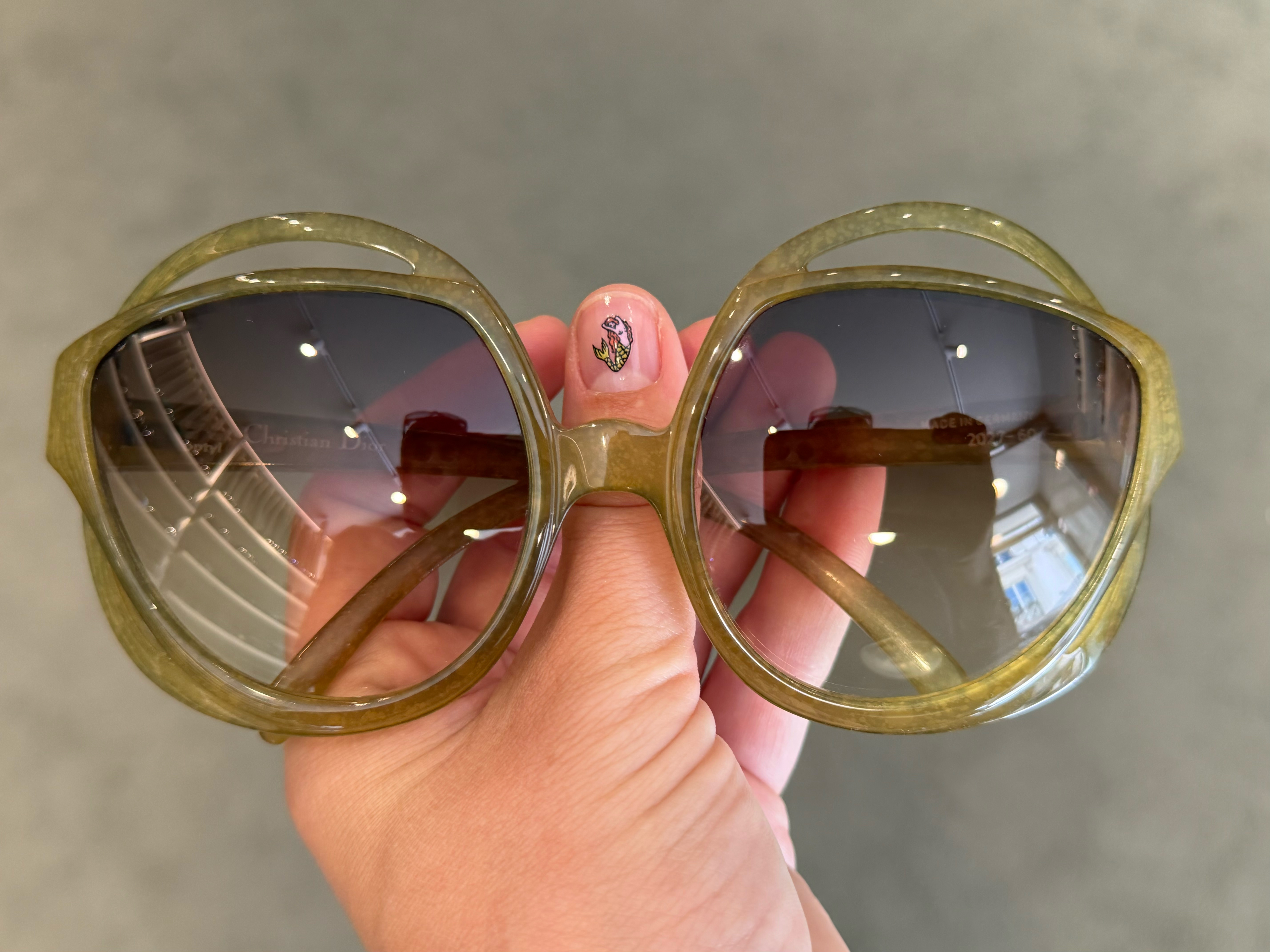 Person holding a pair of '80s sunglasses.