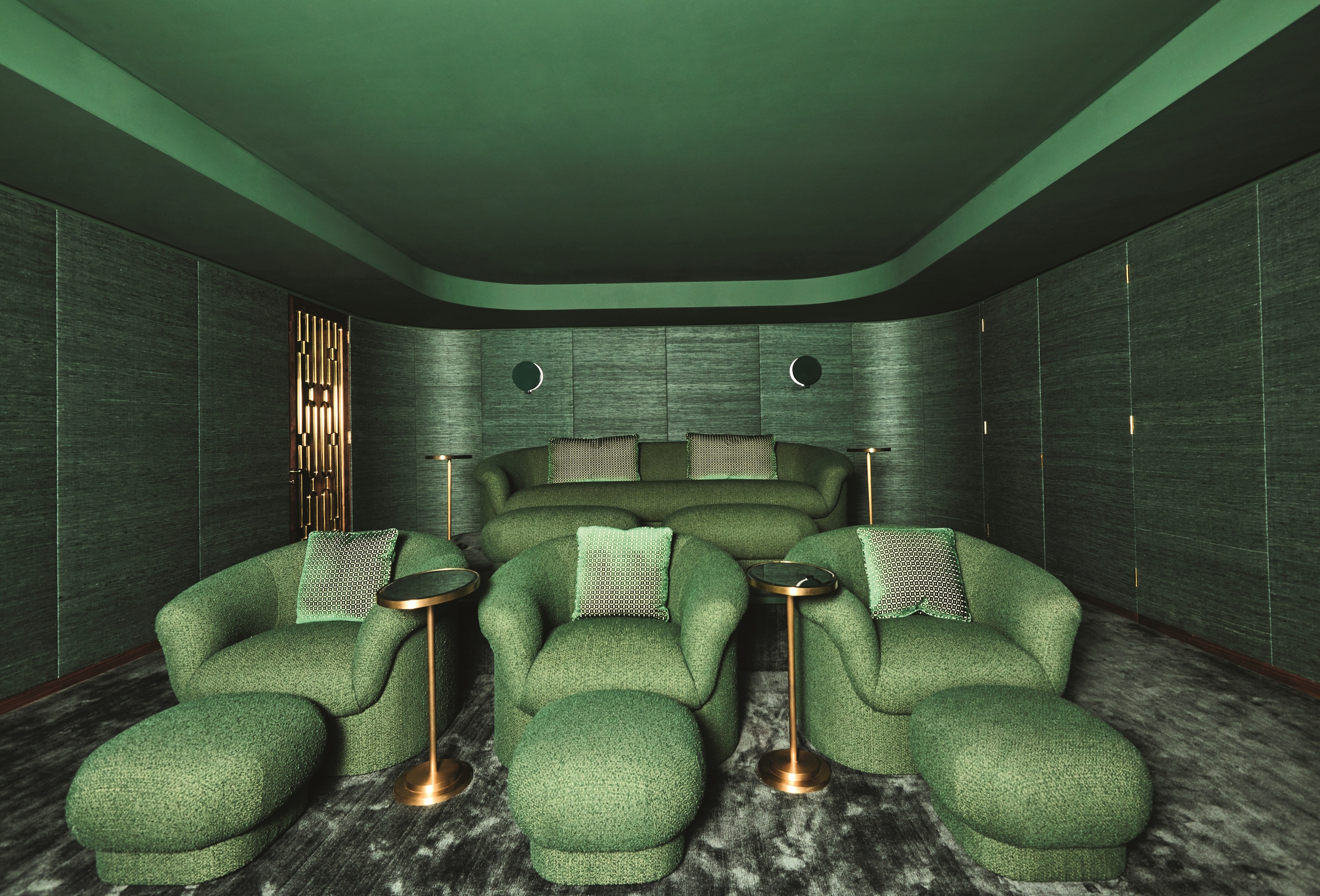 a bright green cinema room with individual seats and a sofa, the tray ceiling is painted green, too