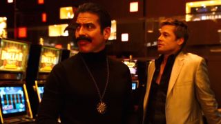 George Clooney stands in disguise with Brad Pitt as they both look at something of interest in Ocean's Thirteen.