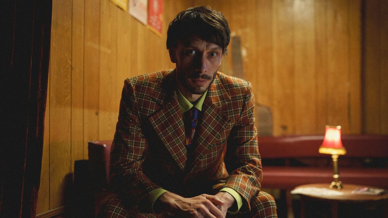 Richard Gadd as Donny Dunn, sitting at a wood-paneled restaurant booth, in &#039;Baby Reindeer&#039;