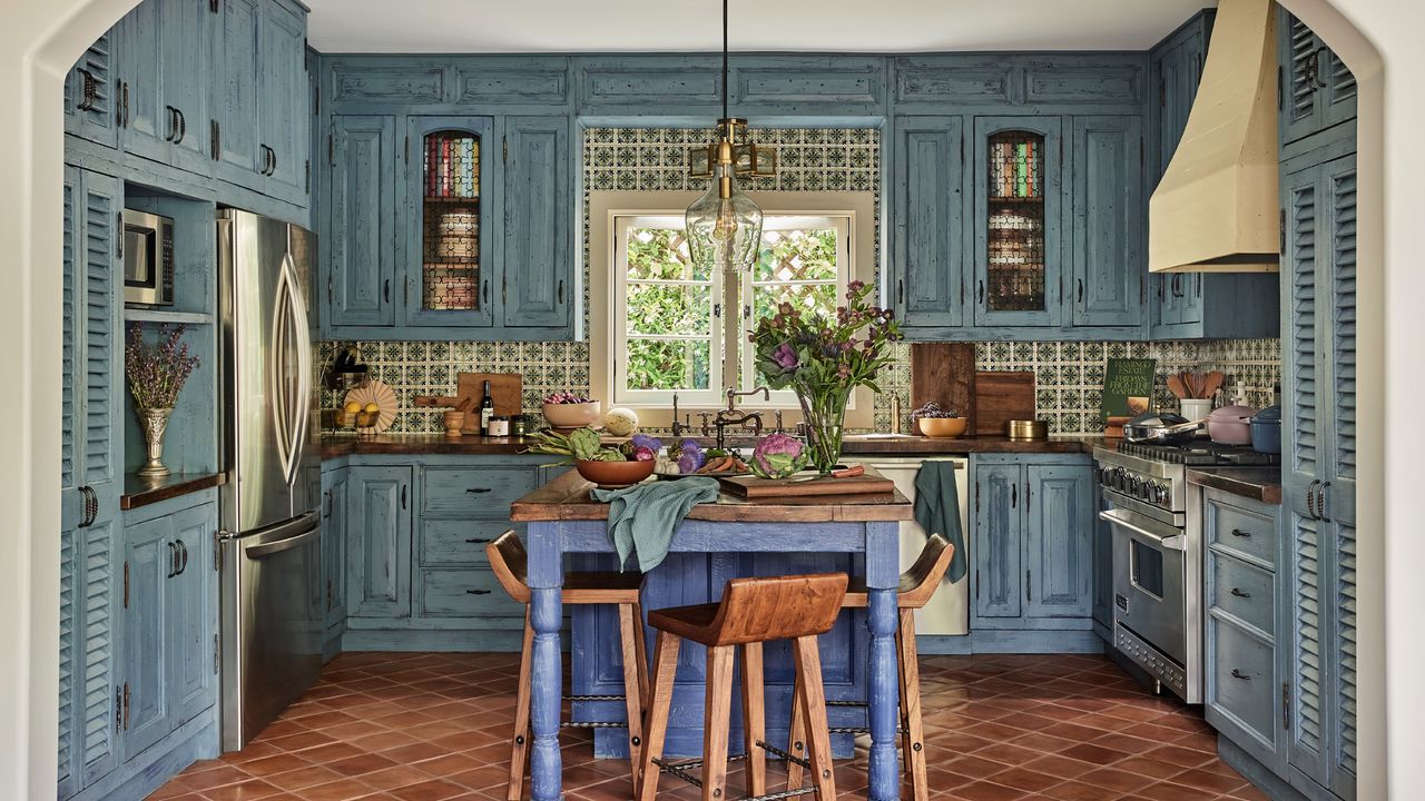 Our Place founder Shiza Shahid&#039;s blue kitchen in her Los Angeles home adorned with Spanish tiles and fitted with the Our Place Wonder Oven, Always Pan and Perfect Pots