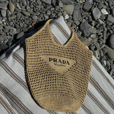 Knitted prada bag on top of a towel