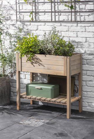 planter with shelf in front of a limewashed outdoor wall