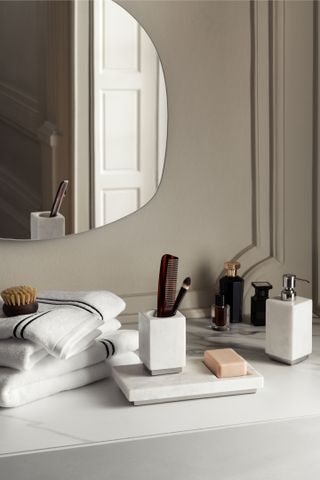 white towels on a bathroom shelf with mirror and bathroom panel coving