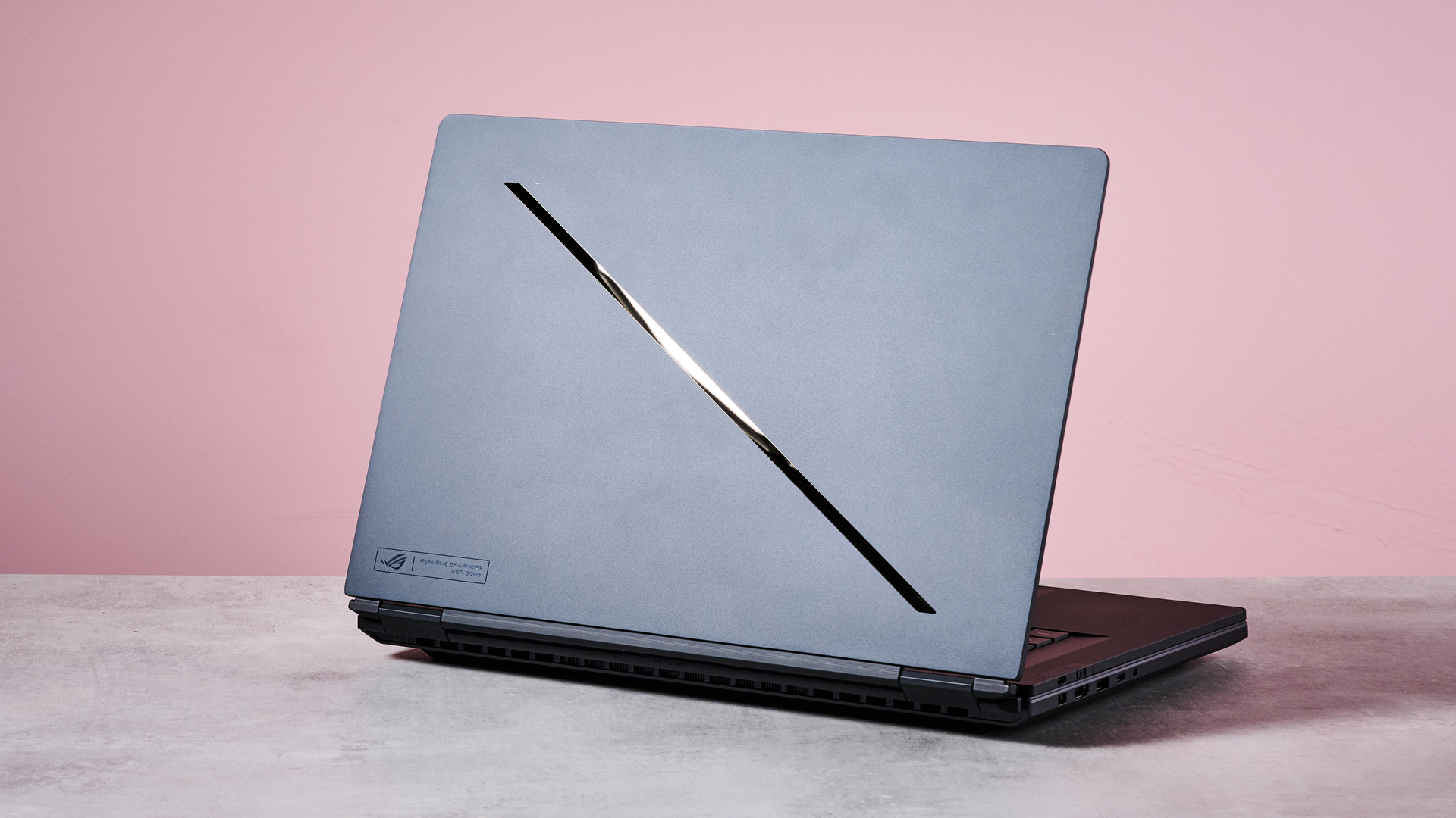 Back three-quarter view of ASUS ROG Zephyrus Duo 2026 on a desk with pink wall in background