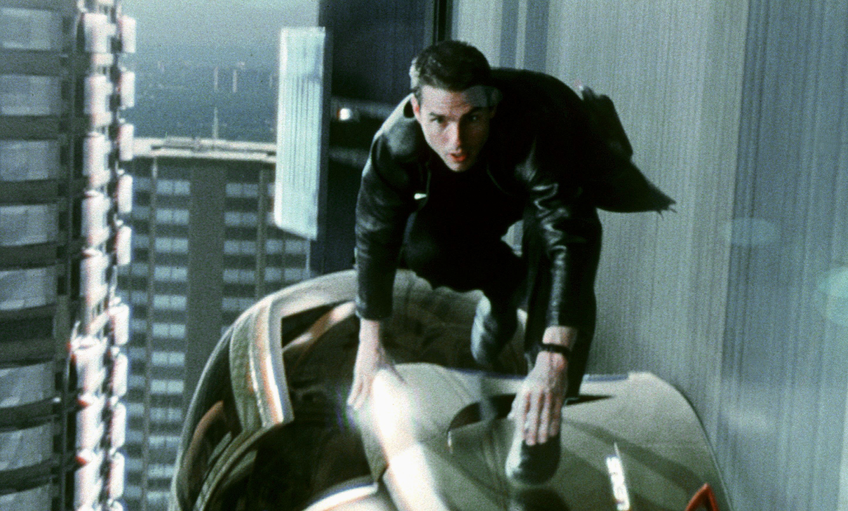 Tom Cruise as John Anderton, kneeling on a ledge in Minority Report