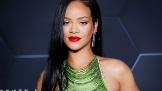 Rihanna wearing shimmering makeup with a bold, bright red lipstick