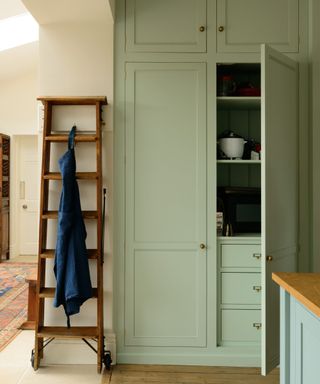 Green appliance garage with integrated drawers below the shelving