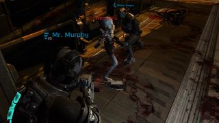 Two humans fighting a Necromorph in Dead Space 2's multiplayer mode.