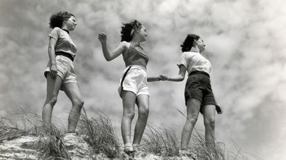 Women holding hands at the edge of a sandbank