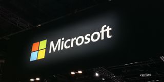 Microsoft logo suspended above a conference floor