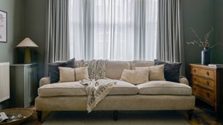 sofa with sheer curtains in blue living room