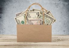 paper shopping bag full of us currency