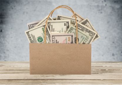 paper shopping bag full of us currency