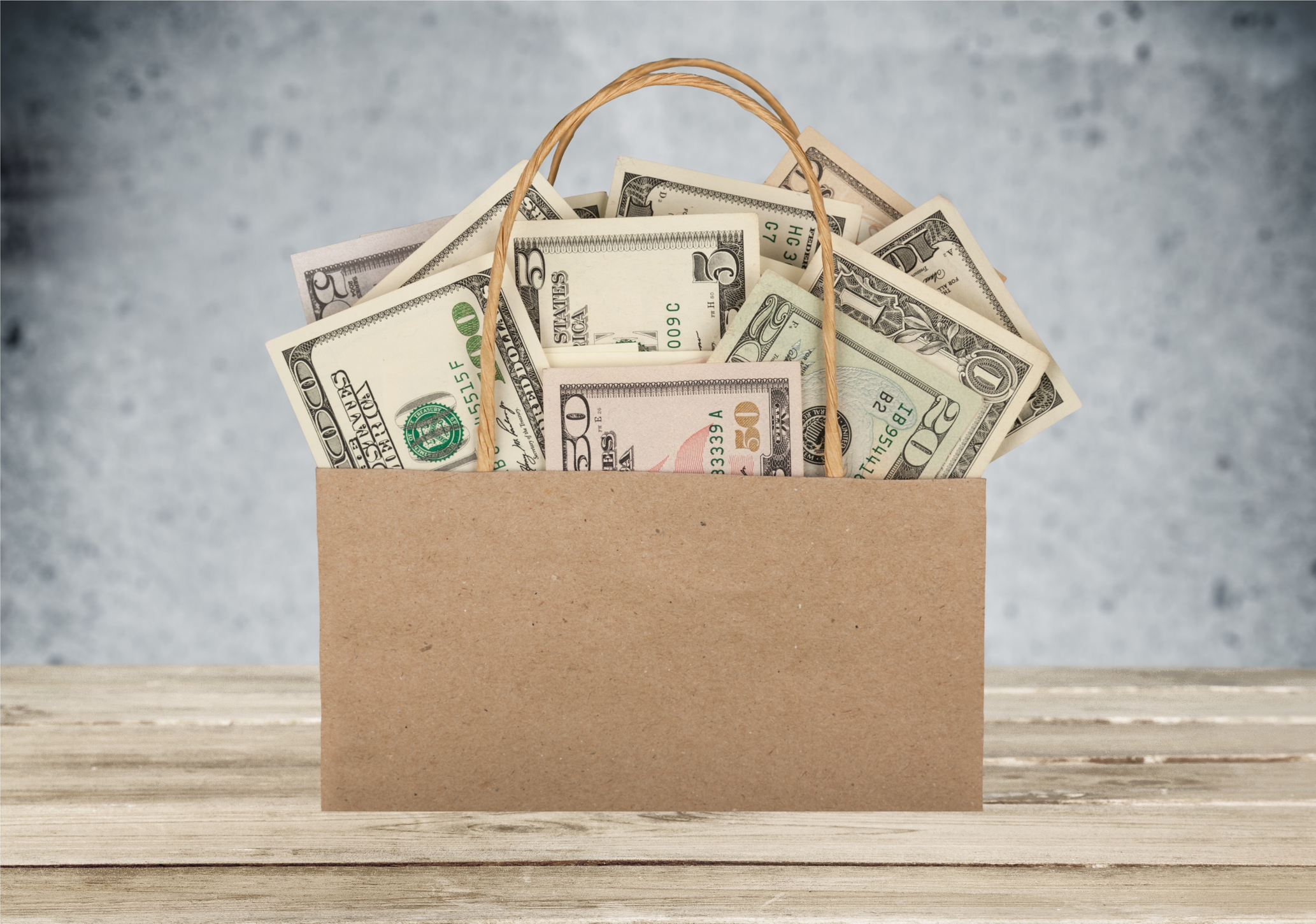 paper shopping bag full of us currency