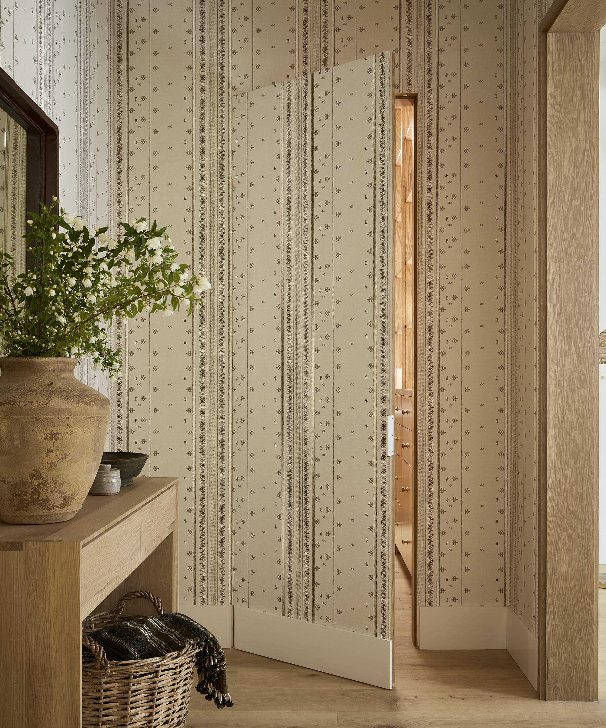 wall and door covered in floral wallpaper with the door slightly open