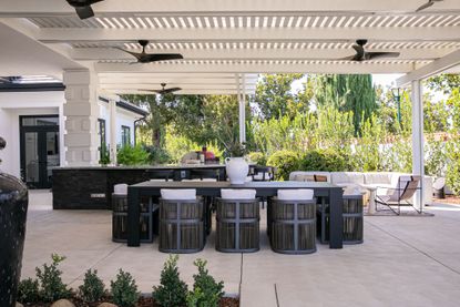 a covered patio area with dining furniture