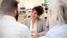 Cheerful female financial adviser having a meeting with two clients