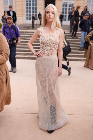 Anya Taylor-Joy at Christian Dior RTW Spring 2025 as part of Paris Ready to Wear Fashion Week held at Musée Rodin on September 24, 2024 in Paris, France wearing a crochet crop top and sheer skirt