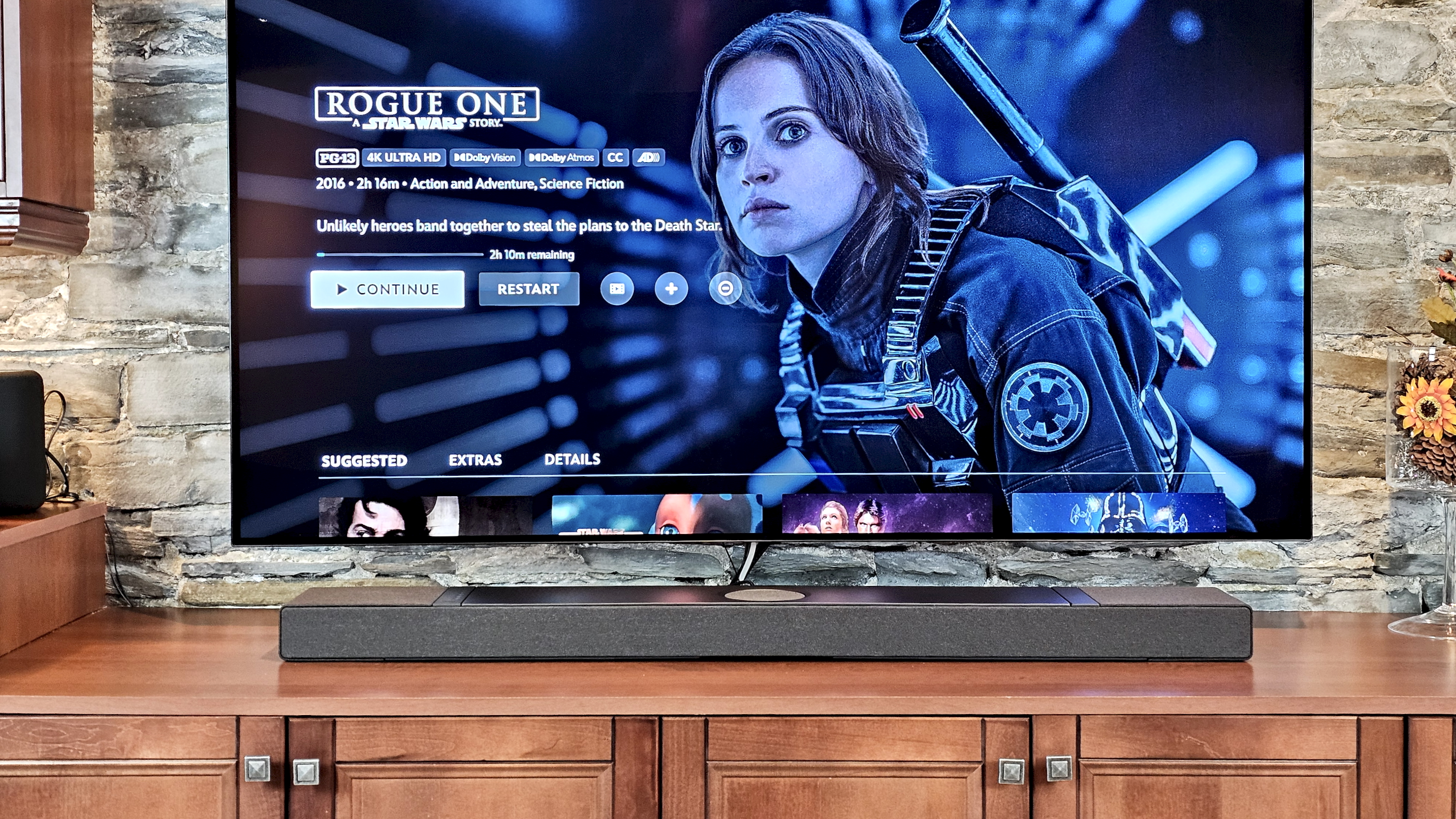 KEF XIO on TV stand with Rogue One menu on screen