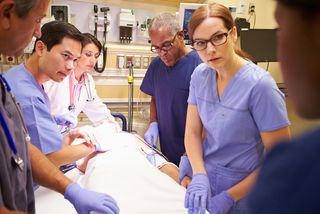 Healthcare workers attend to a patient