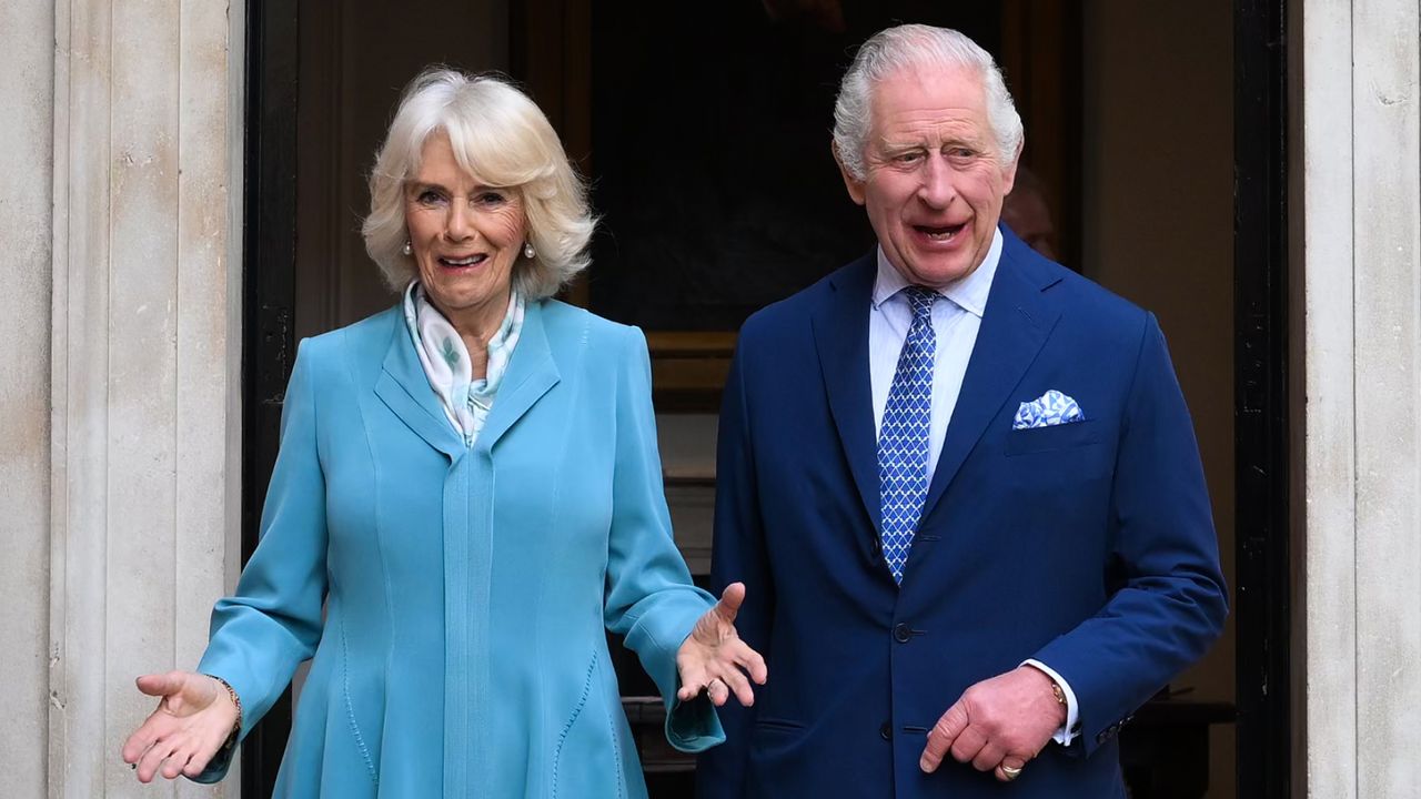 Queen Camilla wears a turquoise dress and King Charles wears a blue suit