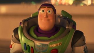 Buzz Lightyear smiles solemnly in the glow of carnival lights in Toy Story 4.