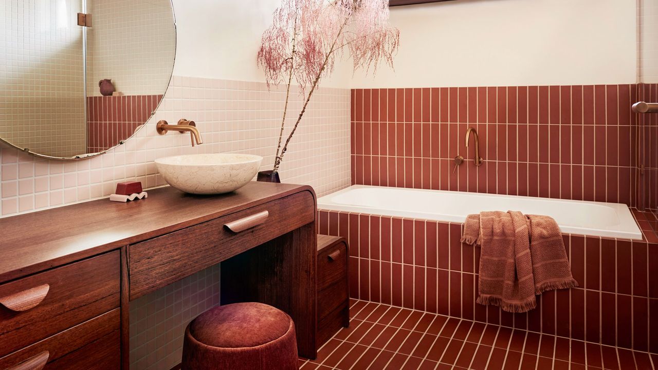 a dark red bathroom with a wood vanity