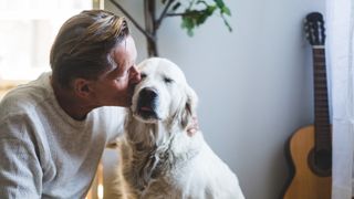 Man giving adult dog a kiss