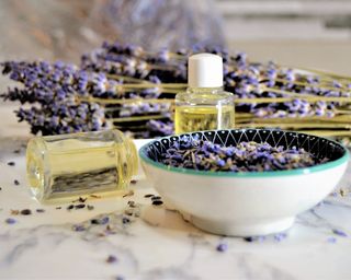 Aromatic oils with lavender flowers on marble background