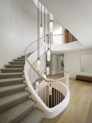 modern staircase with smoothly curved stairs and large pendant light