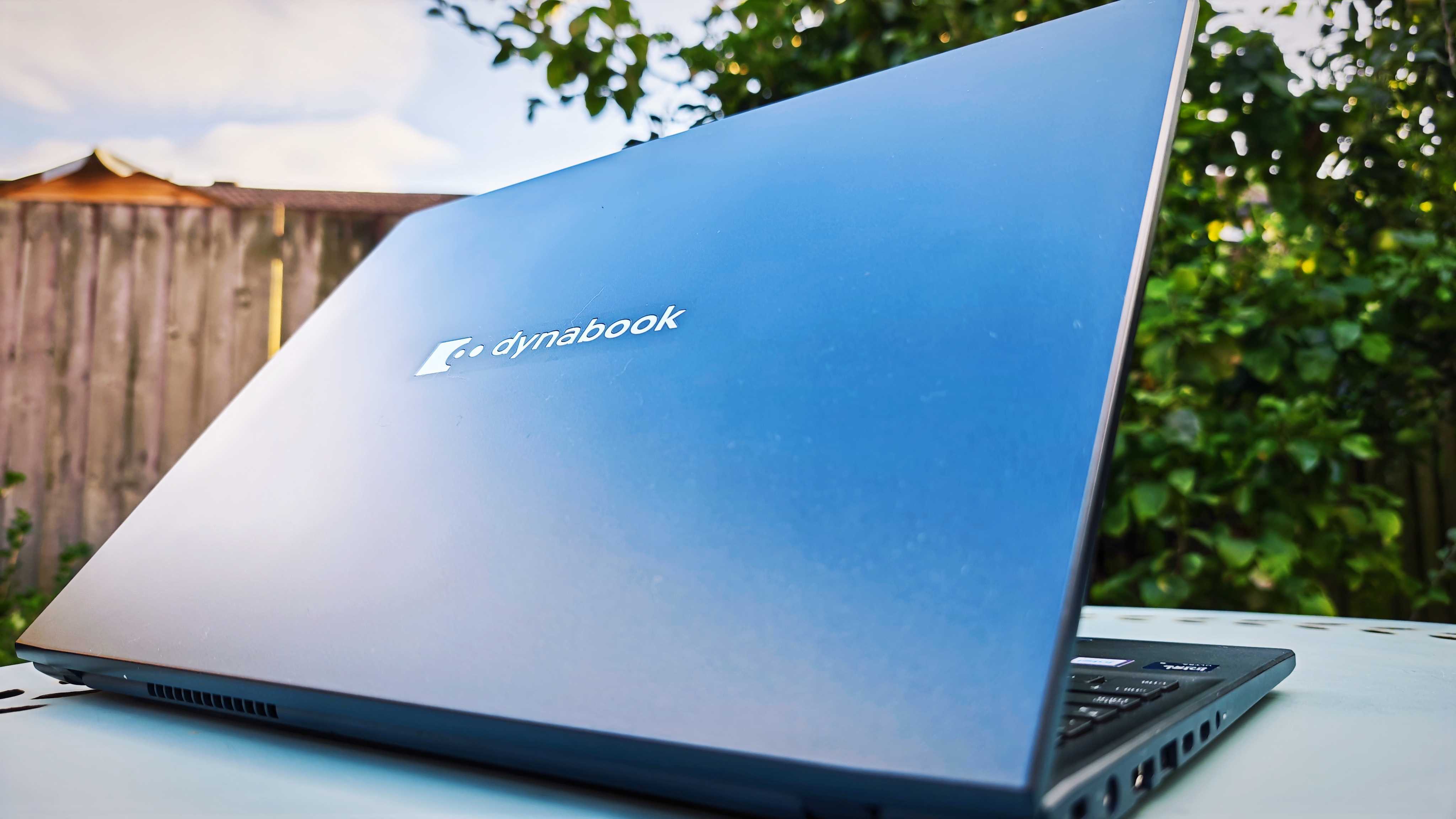 A dark blue Dynabook Tecra A60-M laptop on a garden table