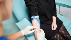 A view of a woman's arm as a nurse puts a needle into her vein