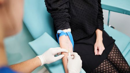 A view of a woman's arm as a nurse puts a needle into her vein